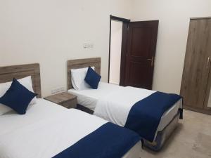Dos camas una al lado de la otra en un dormitorio. en Today House Suites 2, en Salalah
