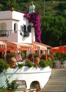 a white building with flowers on the side of it at Hotel Cala di Mola in Porto Azzurro