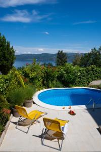 2 Stühle und ein Pool im Hof in der Unterkunft Ferienhaus Nera in Plomin