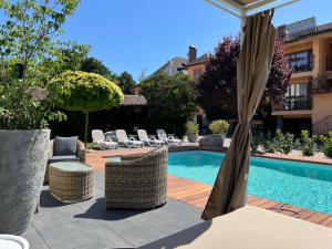 a swimming pool with wicker chairs and a umbrella at Penzion Trattoria in Prešov