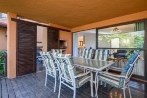 ein Esszimmer mit Tisch und Stühlen auf einer Terrasse in der Unterkunft San Lameer Villa 1933 - 2 Bedroom Classic - 4 pax - San Lameer Rental Agency in Southbroom