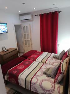 een slaapkamer met 2 bedden en een rood gordijn bij Studio 6 in Târgu-Mureş