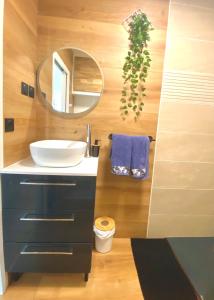 a bathroom with a sink and a mirror at - L'IROIZH - CONCARNEAU - VUE MER PANORAMIQUE - STUDIO STANDING PLAGE DES SABLES BLANCS - PARKING - DRAPS & SERVIETTES INCLUS - NEAR THALASSOTHERAPY - Wifi - in Concarneau +27 photos