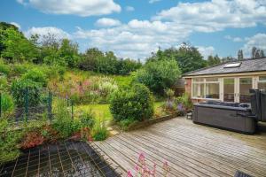 um jardim com uma banheira de hidromassagem num deque de madeira em Luxury Spa Home With Hot Tub Sauna And Pool Table em Chesterfield