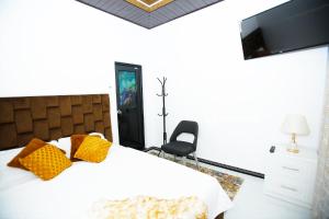 a bedroom with a bed with yellow pillows and a television at Chamsha Hotel in Anuradhapura