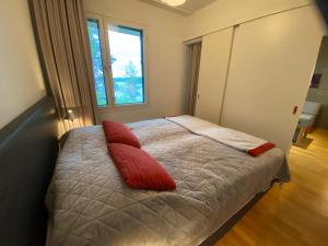 um quarto com uma cama com duas almofadas vermelhas em Vuokatti Chalets Aarni em Vuokatti