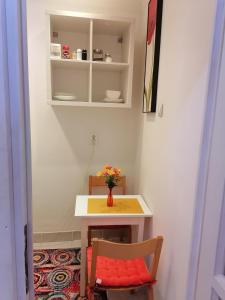 een kleine tafel en een stoel met een vaas met bloemen bij Studio 6 in Târgu-Mureş