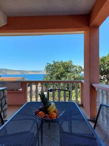 a plate of fruit on a table on a balcony at Apartment Ante and Dijana in Starigrad-Paklenica
