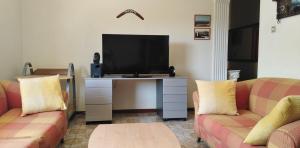 uma sala de estar com 2 sofás e uma televisão de ecrã plano em Ομορφο διαμερισμα με μεγαλες βεραντες em Atenas