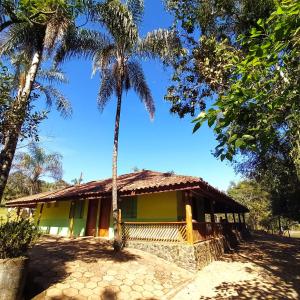 聖羅克迪米納斯的住宿－Pousada, Camping e Restaurante Recanto do Surubim，前面有棕榈树的房子