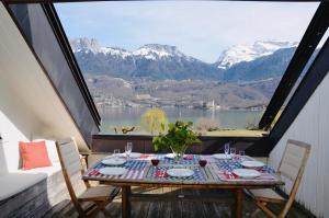 Una mesa en un balcón con vista a las montañas. en Lac paradisiaque, en Duingt