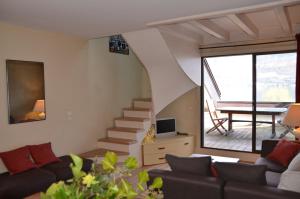 a living room with a couch and a stairway at Lac paradisiaque in Duingt