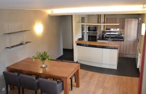 a kitchen and dining room with a wooden table and a table at Lac paradisiaque in Duingt