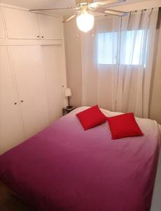 una camera da letto con un grande letto con due cuscini rossi di Casa Bianca Wifi5G 56m2 DoubleRoom a Puerto de la Cruz
