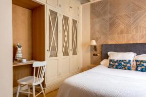 1 dormitorio con cama, silla y escritorio en CH Apartments Boutique en Sevilla