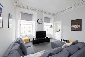 - un salon avec un canapé et une télévision dans l'établissement ALTIDO Splendid 4-bed Flat Near The Castle, à Édimbourg