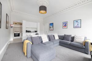 Il comprend un salon avec un canapé et une cuisine. dans l'établissement ALTIDO Splendid 4-bed Flat Near The Castle, à Édimbourg