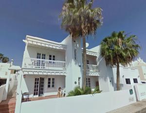 ein weißes Haus mit Palmen davor in der Unterkunft Le Family Palms My Home in Playa Honda
