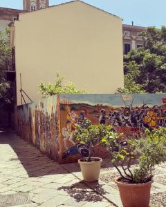 eine Wand mit Graffiti drauf mit Pflanzen davor in der Unterkunft Zanclea in Palermo