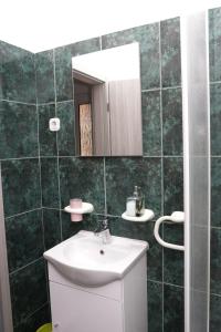 a bathroom with a sink and a mirror at Apartmani Eni in Seget Vranjica