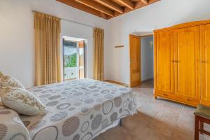 a bedroom with a bed and a large window at Cas Consul in Puerto de San Miguel