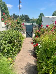 a garden with red flowers and a blue gate at Honfleur house in Honfleur