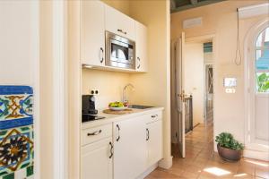 a kitchen with white cabinets and a sink at CH Apartments Boutique in Seville