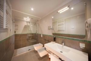 łazienka z umywalką, toaletą i wanną w obiekcie Hotel Aria w Rimini