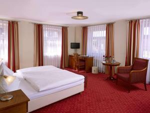 a hotel room with a bed and a desk and chairs at Schloss-Gasthof Sonne in Isny im Allgäu