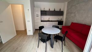 ein Wohnzimmer mit einem roten Sofa, einem Tisch und Stühlen in der Unterkunft San Rocco Apartments - Royal Welcome in Verona