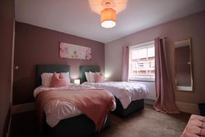 a bedroom with two beds and a window at West Street Retreat Grade II listed townhouse in Harwich