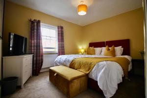 a bedroom with a large bed and a television at West Street Retreat Grade II listed townhouse in Harwich