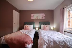 two beds sitting next to each other in a bedroom at West Street Retreat Grade II listed townhouse in Harwich