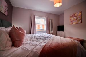 a bedroom with a white bed with a window at West Street Retreat Grade II listed townhouse in Harwich