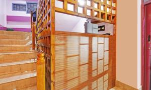 uma porta de madeira que dá acesso a um quarto com escadas em Itsy By Treebo - Shillong Tower Guesthouse em Shillong