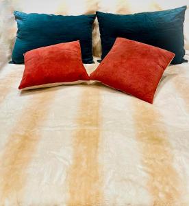 Una cama con dos almohadas rojas. en Jasmine Studio, en Radom