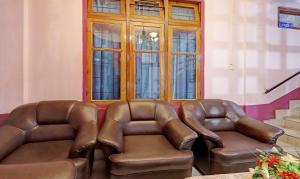dois assentos de couro castanho num quarto com uma janela em Itsy By Treebo - Shillong Tower Guesthouse em Shillong
