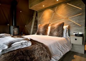 a bedroom with a bed with a wooden wall at Finest Retreats - Hever Luxury Dome 