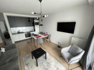 uma sala de estar com uma mesa e uma cadeira em Nowy apartament w okolicach centrum em Siedlce