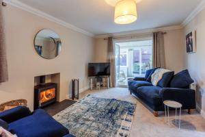 a living room with a blue couch and a fireplace at Potters Brook in Framlingham