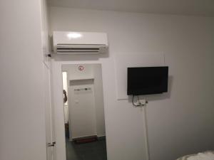 a room with a tv on the wall and a hallway at Kalidonia “PANORAMA” STUDIO APARTMENT in İncirli