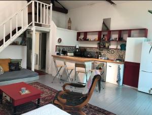 a living room with a kitchen with a spiral staircase at Petit paradis in Vic-Fezensac
