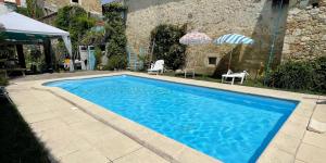 a large blue swimming pool next to a building at Petit paradis in Vic-Fezensac