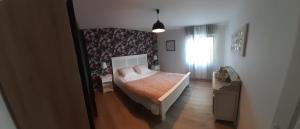 Un dormitorio con una cama grande y una ventana en Adorable maison d’hôtes bordée d’étangs au calme. en Grandcourt