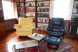 a living room with two chairs and a book shelf at Schreiner in Daun