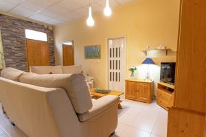 a living room with a couch and a tv at Apartamento Alcazaba in Úbeda