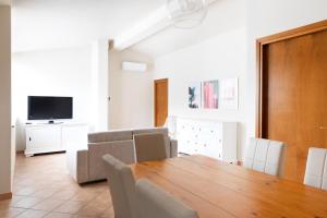 a dining room with a wooden table and a television at Appartamento La Terrazza in Portoferraio