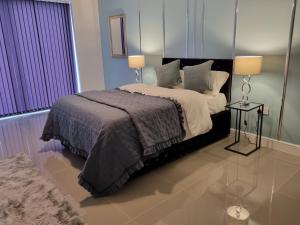 a bedroom with a large bed with two lamps at MNA Superior Apartments in Bradford