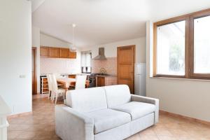 a living room with a white couch and a kitchen at Appartamento La Terrazza in Portoferraio +9 photos