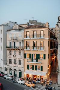 a building with cars parked in front of it at New York Luxury Suites in Corfu